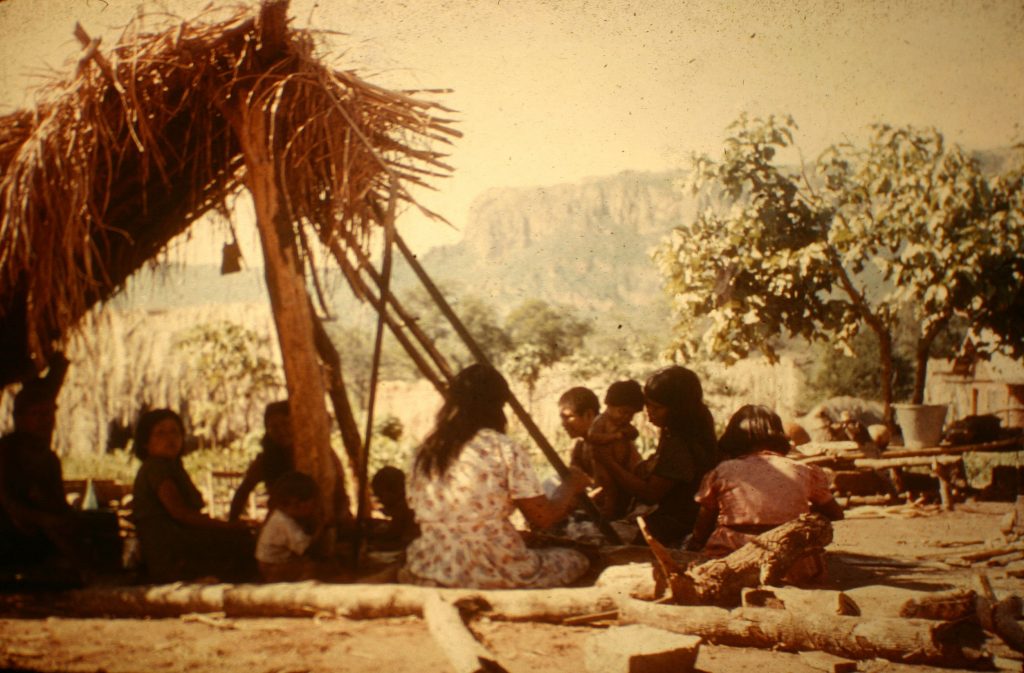 Ayore ladies in lean to weaving and visiting.