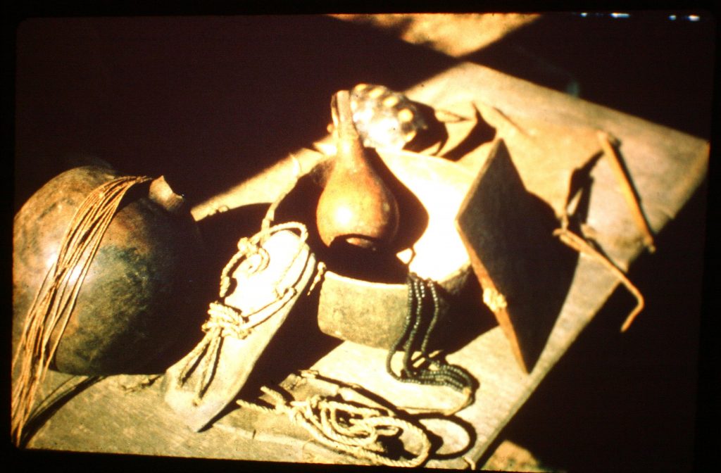 Ayoré artifacts - clay water jug, tapir hide sandals, maraca, gourd bowl, wooden whistle, woman's beads, men's rope