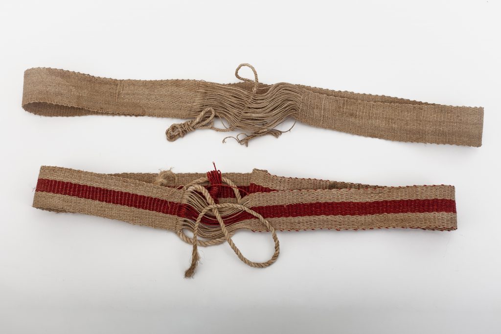 Woven belts or straps used by older men as a back support (wrapped around body, and then about the bended knee.